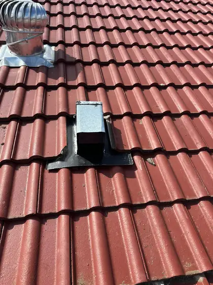 Steel possum one way door fitted on a terracotta tiled roof
