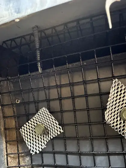 Heavy welded mesh fixed over a roof opening with steel patches
